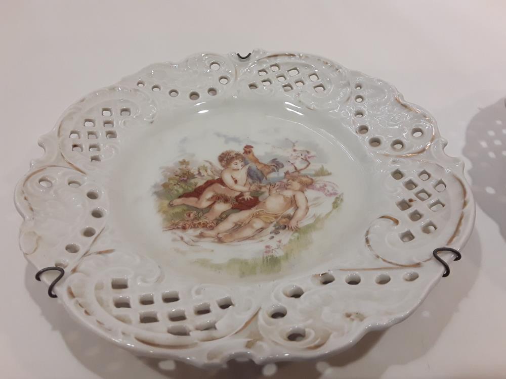 LOT DE DEUX ASSIETTES PEINTES AJOURÉES À MOTIF CHÉRUBINS
