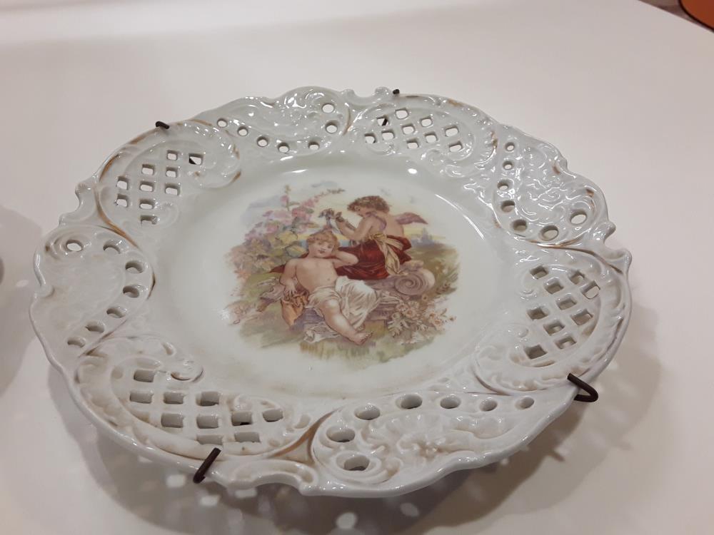 LOT DE DEUX ASSIETTES PEINTES AJOURÉES À MOTIF CHÉRUBINS