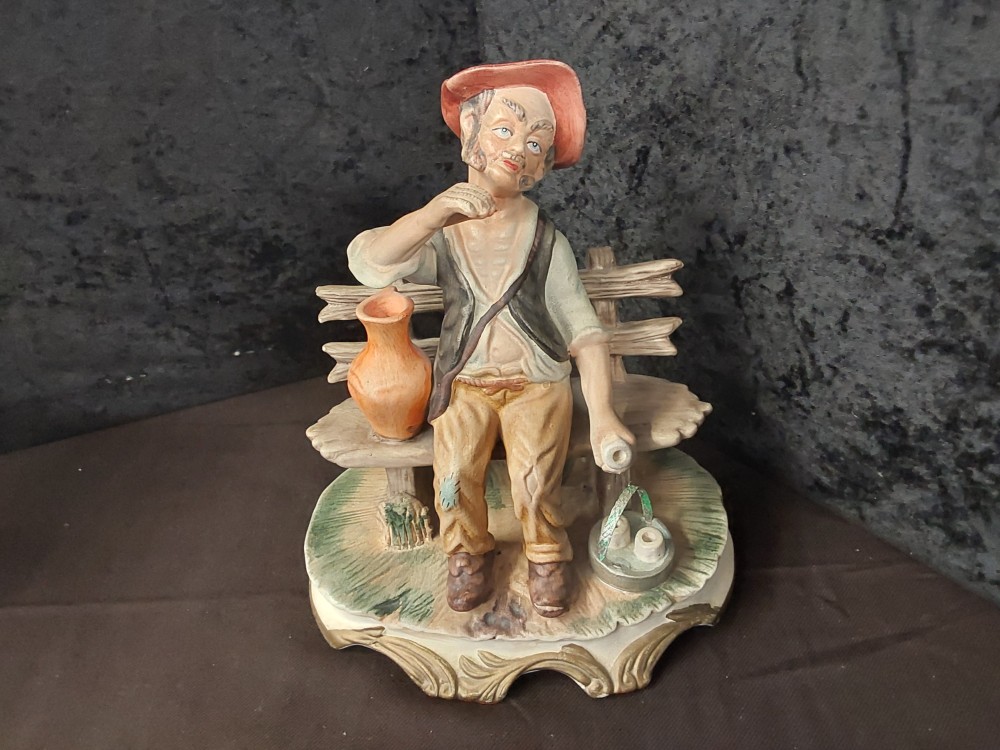 Statue En Porcelaine Personnage Sur Son Banc H.20Cm