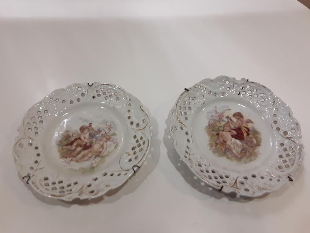 LOT DE DEUX ASSIETTES PEINTES AJOURÉES À MOTIF CHÉRUBINS